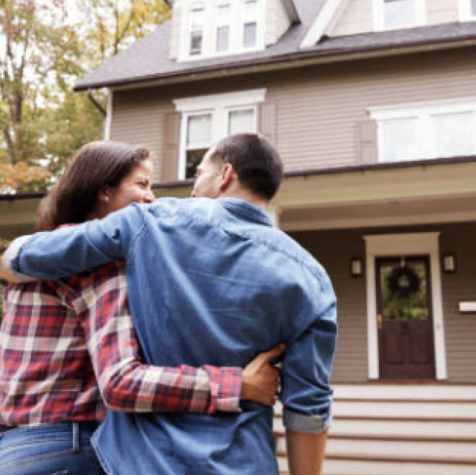 Couple embracing walking into home