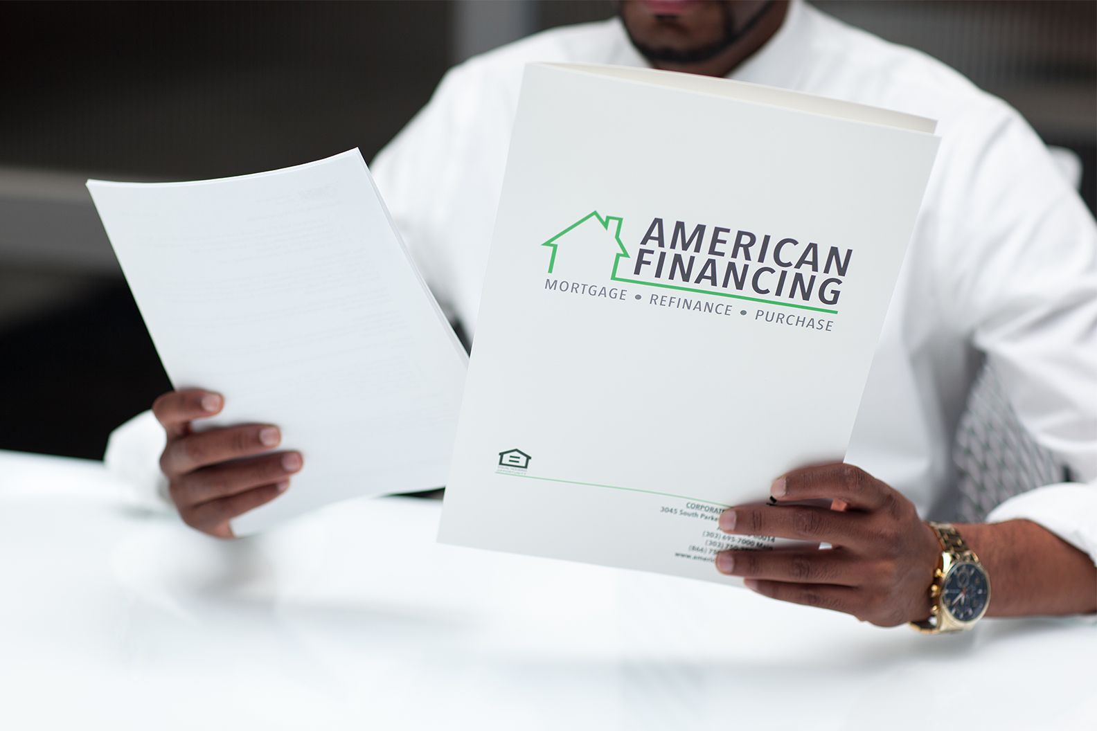 American Financing employee looking at folders with loan documents