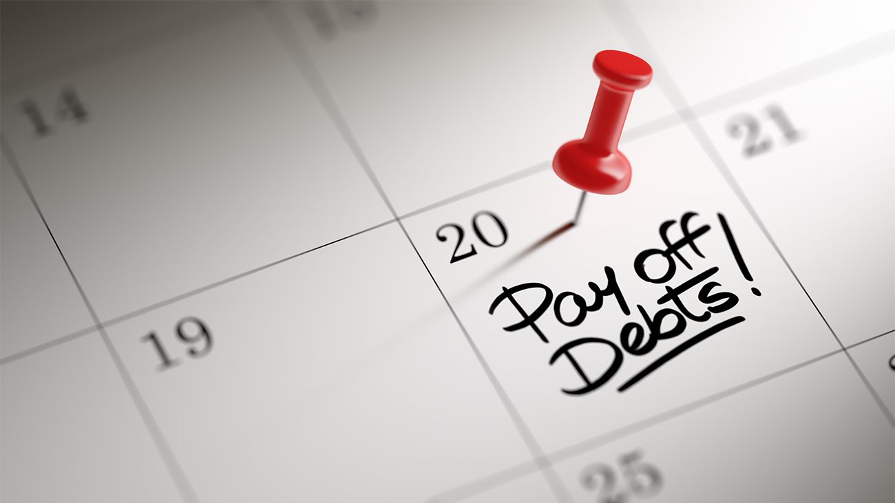 Calendar with a tack on the date to pay off debts.