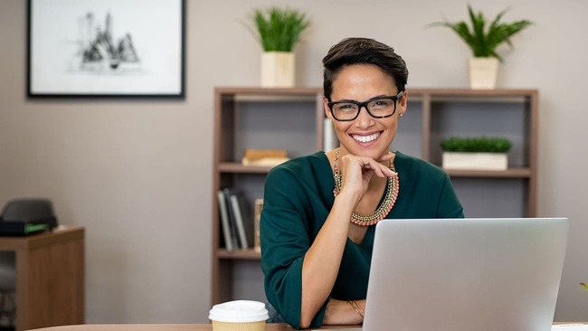 Smiling businesswoman in office with laptop 