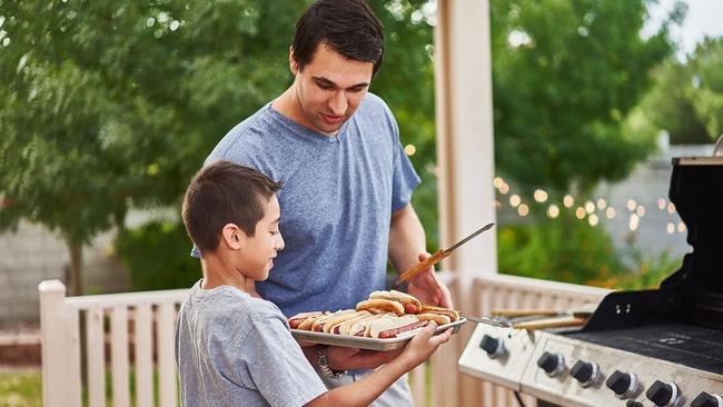 Father and son grilling in backyard
