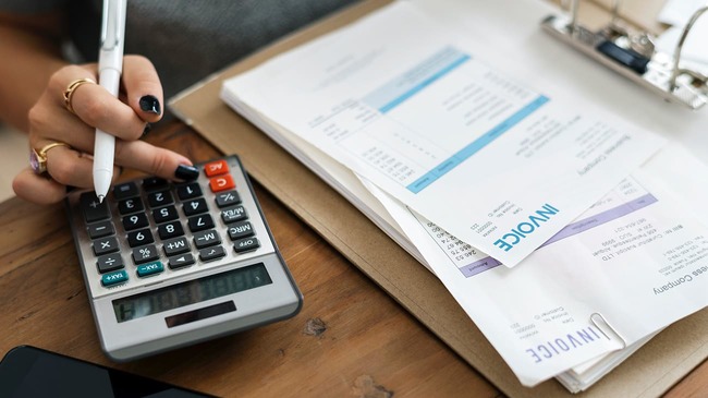 woman using calculator to add up bills