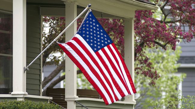 American flag hanging in front of covered porch