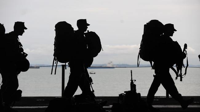 Military men walking near water