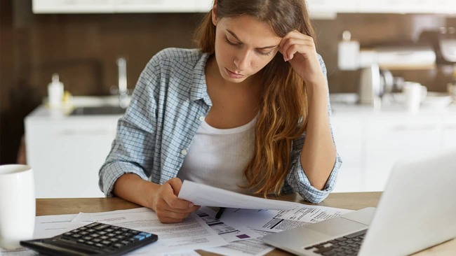 Stressed woman reviewing finances in kitchen
