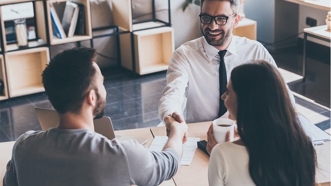 Happy couple meeting with real estate agent