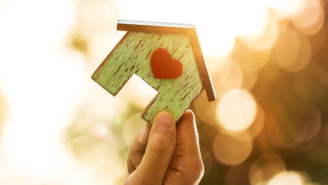 Hand holding wooden toy house