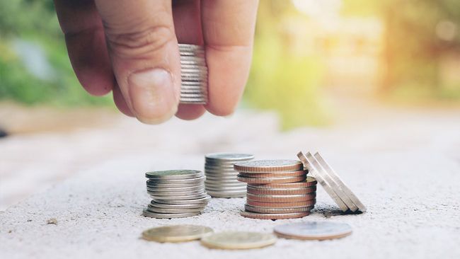Hand placing coins in piles
