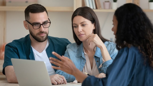 Young couple discussing loan application with lender