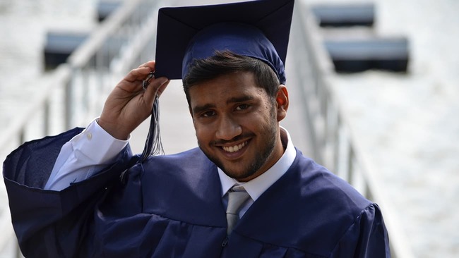 College graduate holding his cap