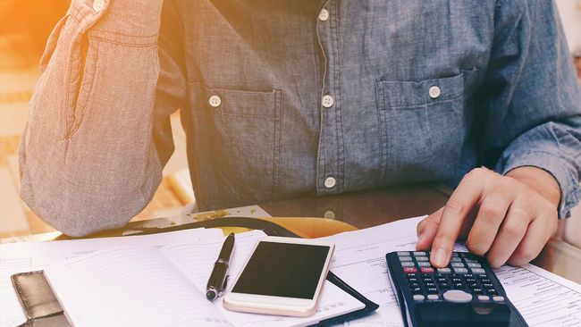 Man at desk calculating mortgage debt