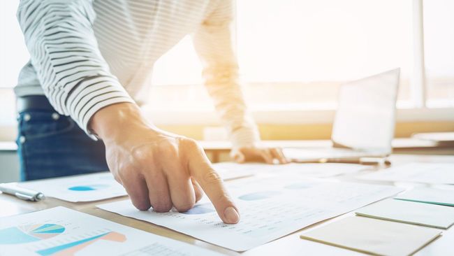 Man pointing to a mortgage payment sheet on a desk