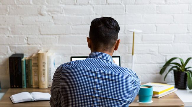 Man at home researching mortgage loans on laptop