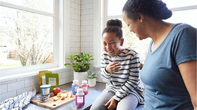 Mother and daughter laughing in kitchen