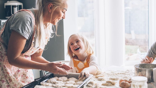 Mother and daughter smiling at each other at a table