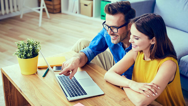 A couple is completing an online mortgage application via a computer.