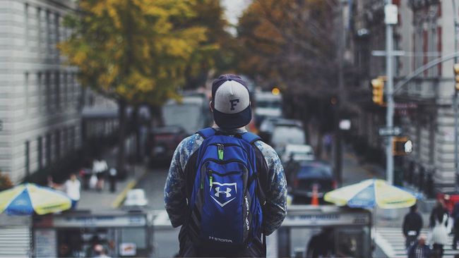 Millennial man standing and staring at city street