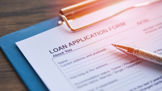 Loan application form and pen on clipboard