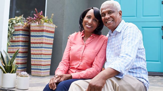 Senior couple on front door porch of house