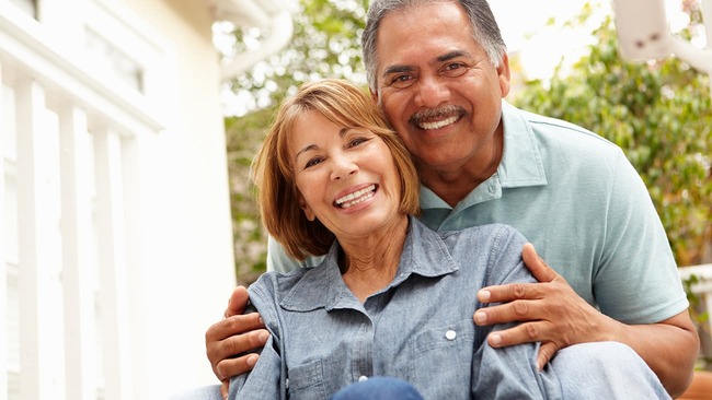 Senior couple smiling and relaxing in yard