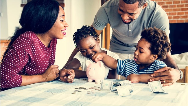 Family putting money into piggy bank