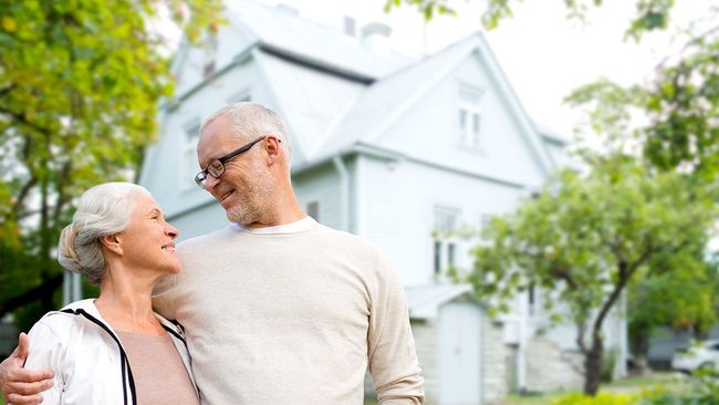Senior couple standing outside retirement home