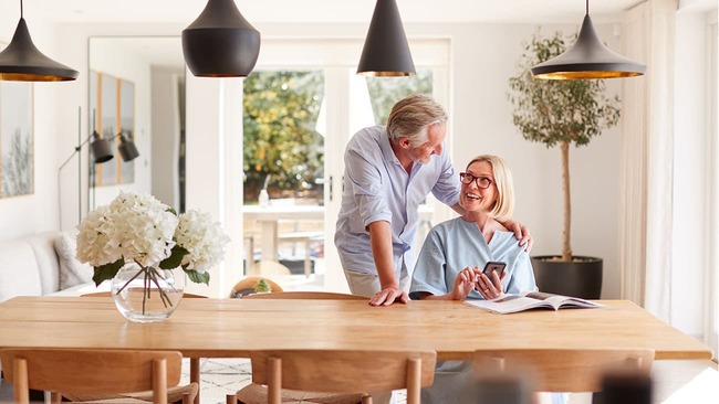 Elderly couple smiling at each other at the kitchen table
