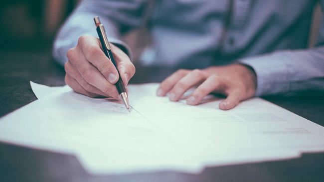 Man reviewing documents with pen in hand