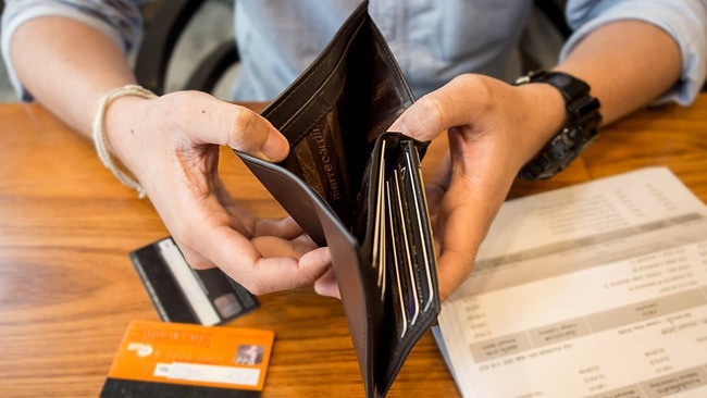 Man looking into wallet for money and credit cards.