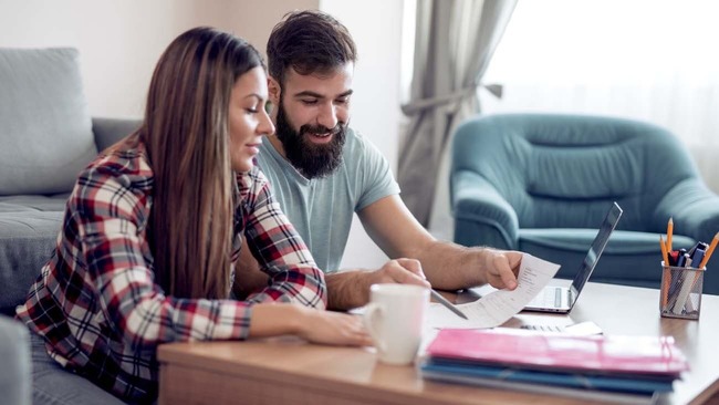 Couple reviewing budget in living room