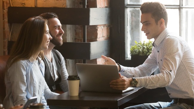 Couple talking with lender at coffee shop 