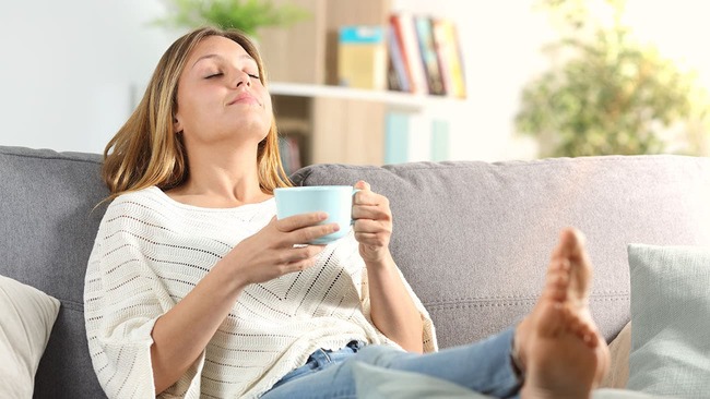 Woman relaxing on the couch with a cup of tea