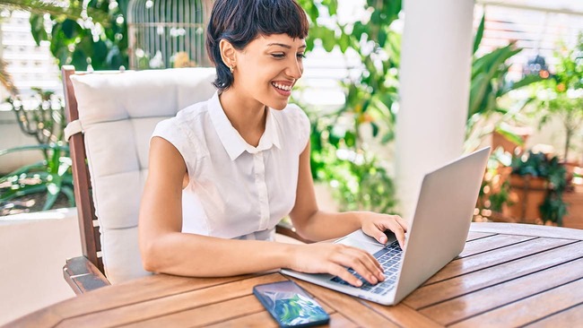 Woman researching on her laptop while outside